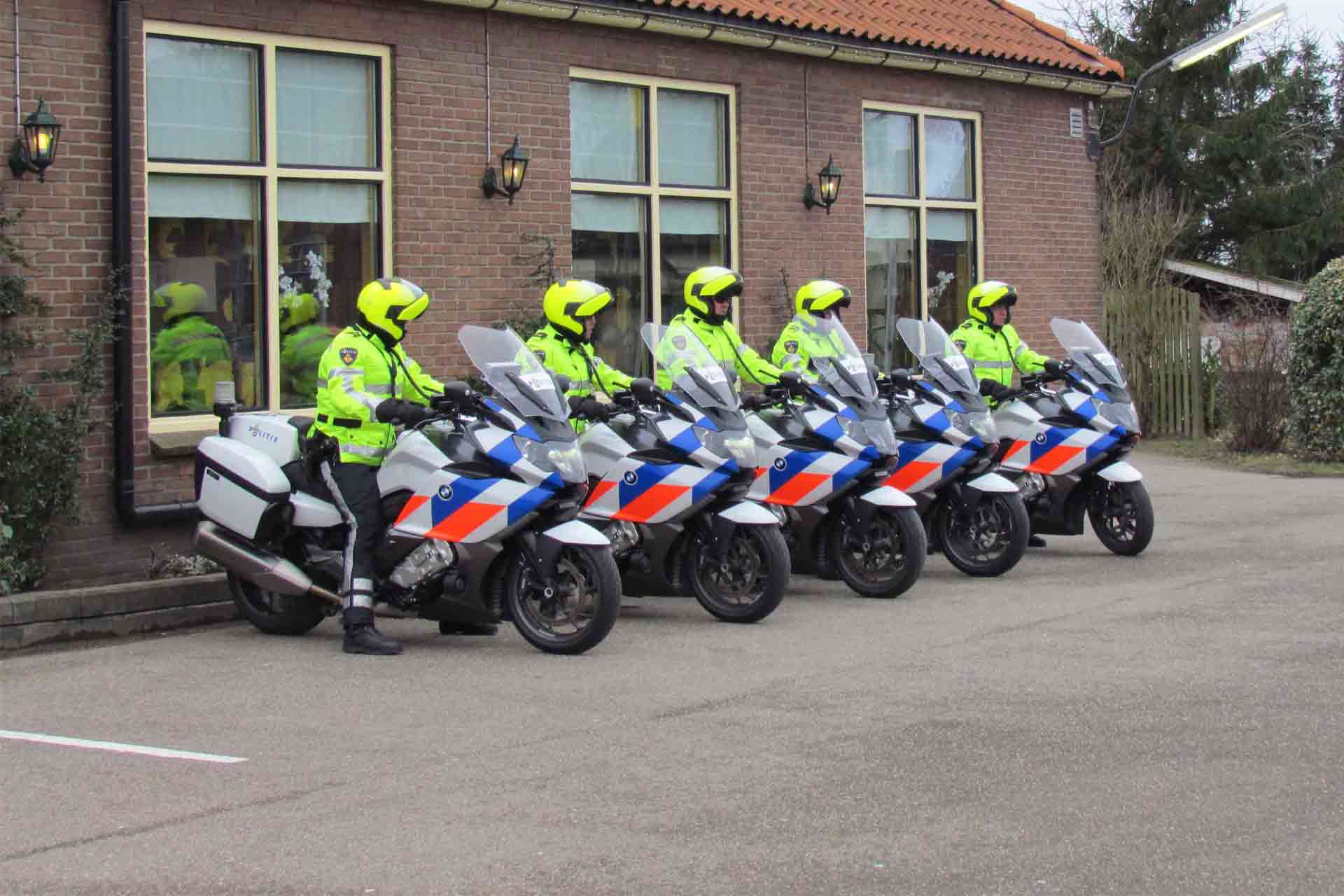 5 motoragenten staan voor een huis met een stagiair van de opleiding Integrale veiligheidskunde