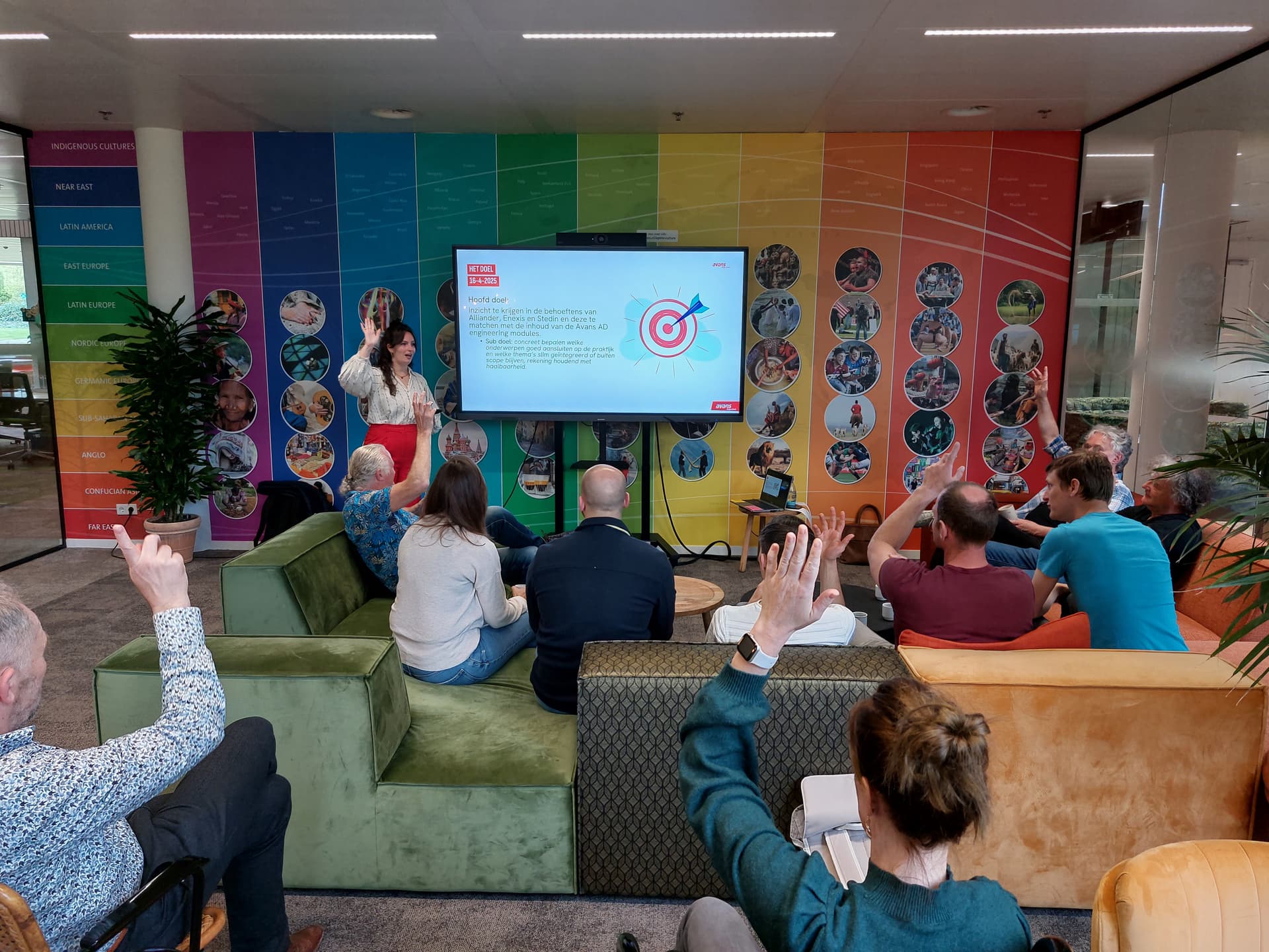 Een groep mensen die samenkomen voor een presentatie in OpenX