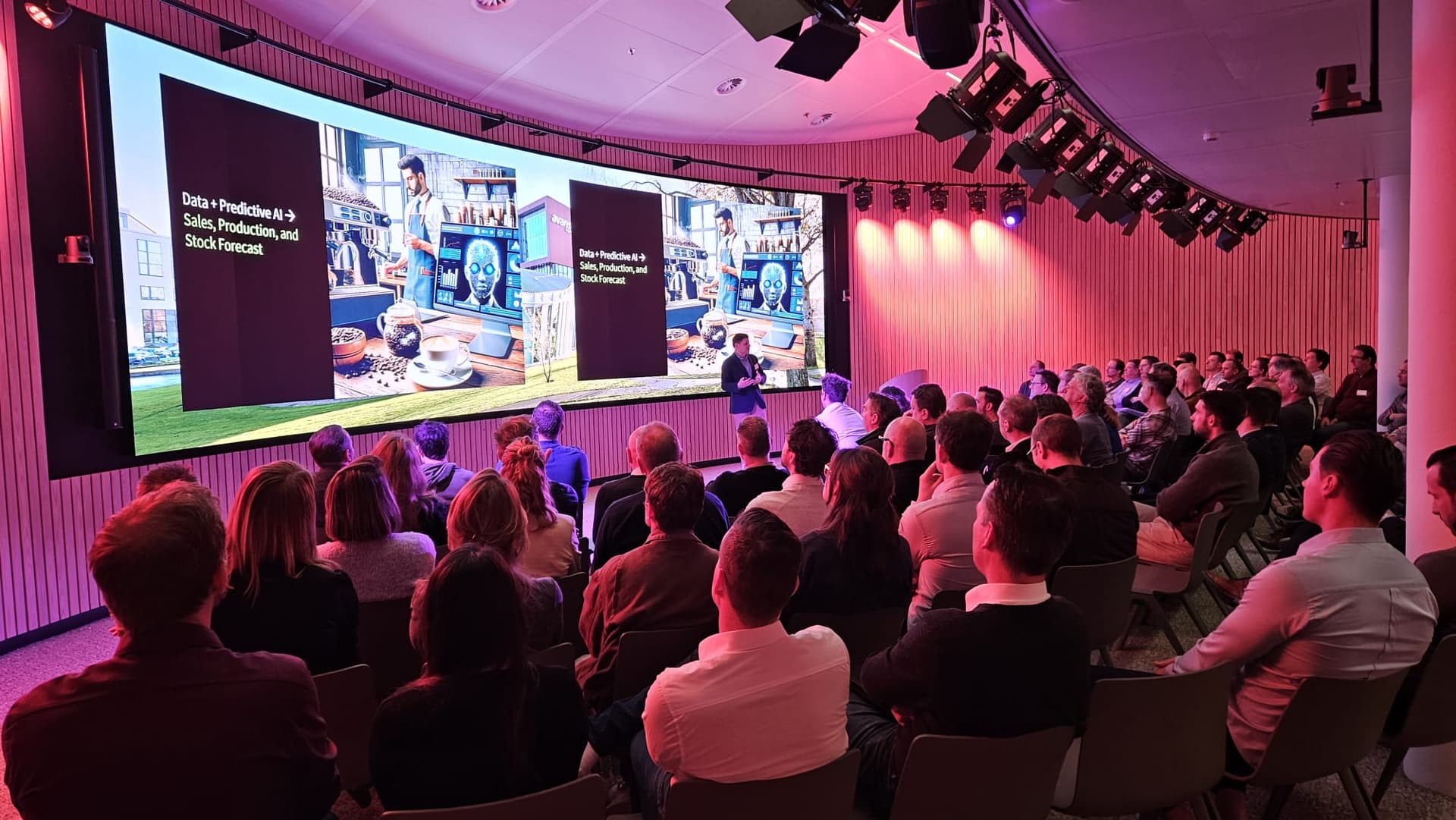 Een bijeenkomst in een zaal van OpenX met een spreker
