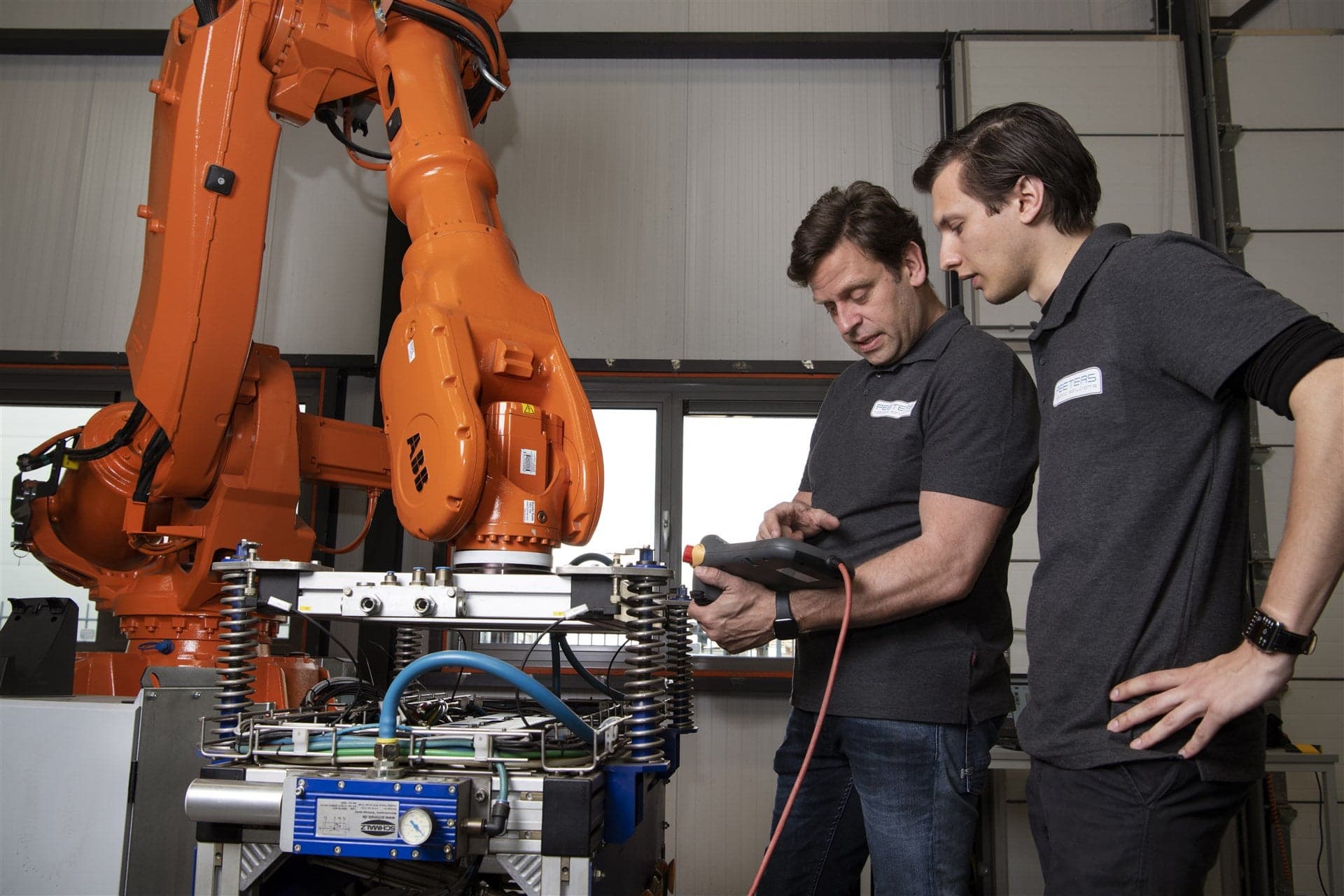 2 Engineers staan bij een robotarm