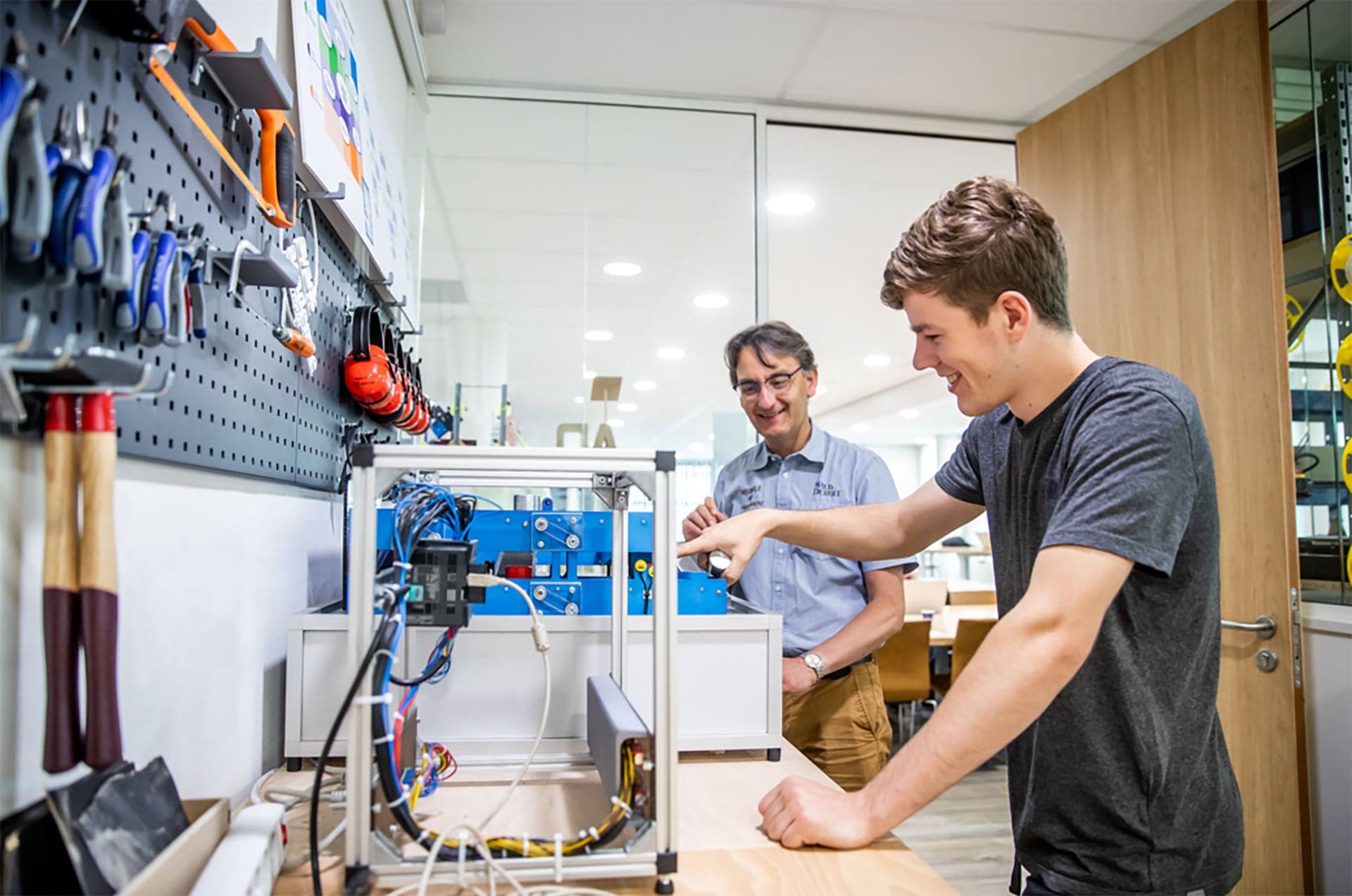 Technische Bedrijfskunde student werkt samen met een docent aan een apparaat