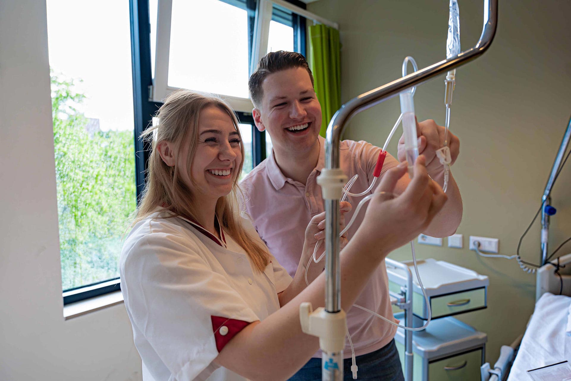 2 studenten van de opleiding Verpleegkunde voltijd bij Avans Hogeschool staan bij een infuus