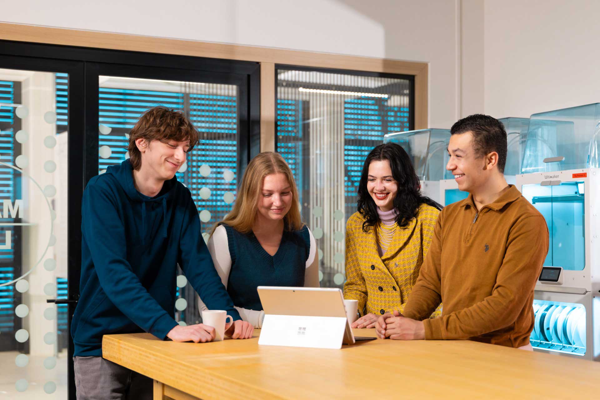 4 studenten van de Master AI-Translator staan bij een laptop