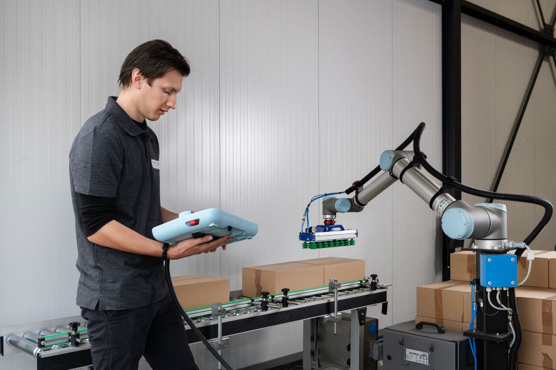 Student deeltijd Engineering staat bij een robotarm