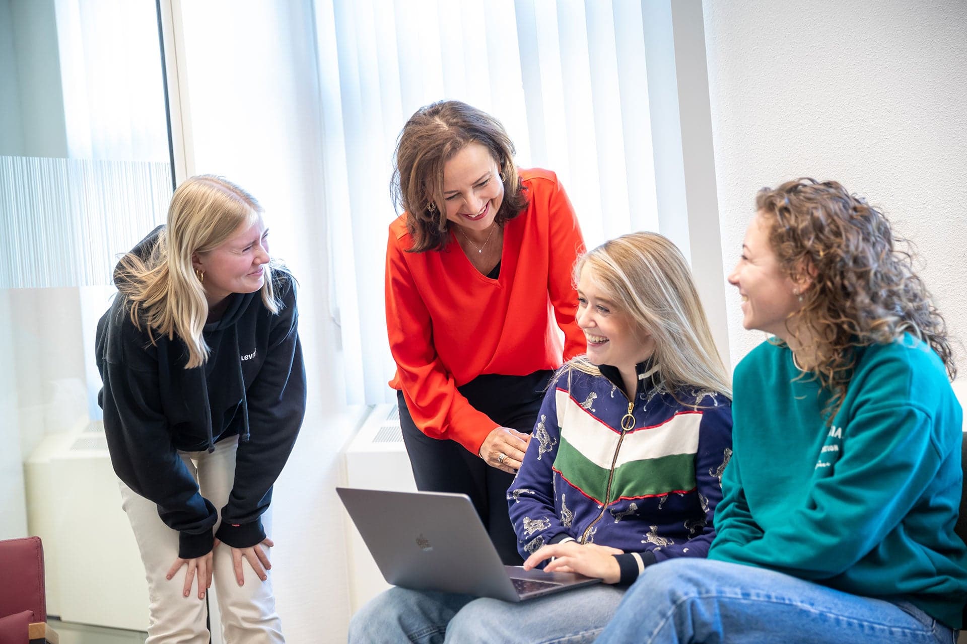 Drie ad-studenten zijn in gesprek met een Associate degree docent