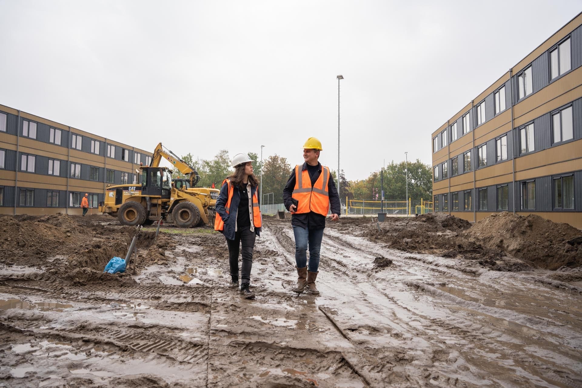 twee studenten Bouwtechnische Bedrijfskunde lopen over een bouwterrein in Tilburg