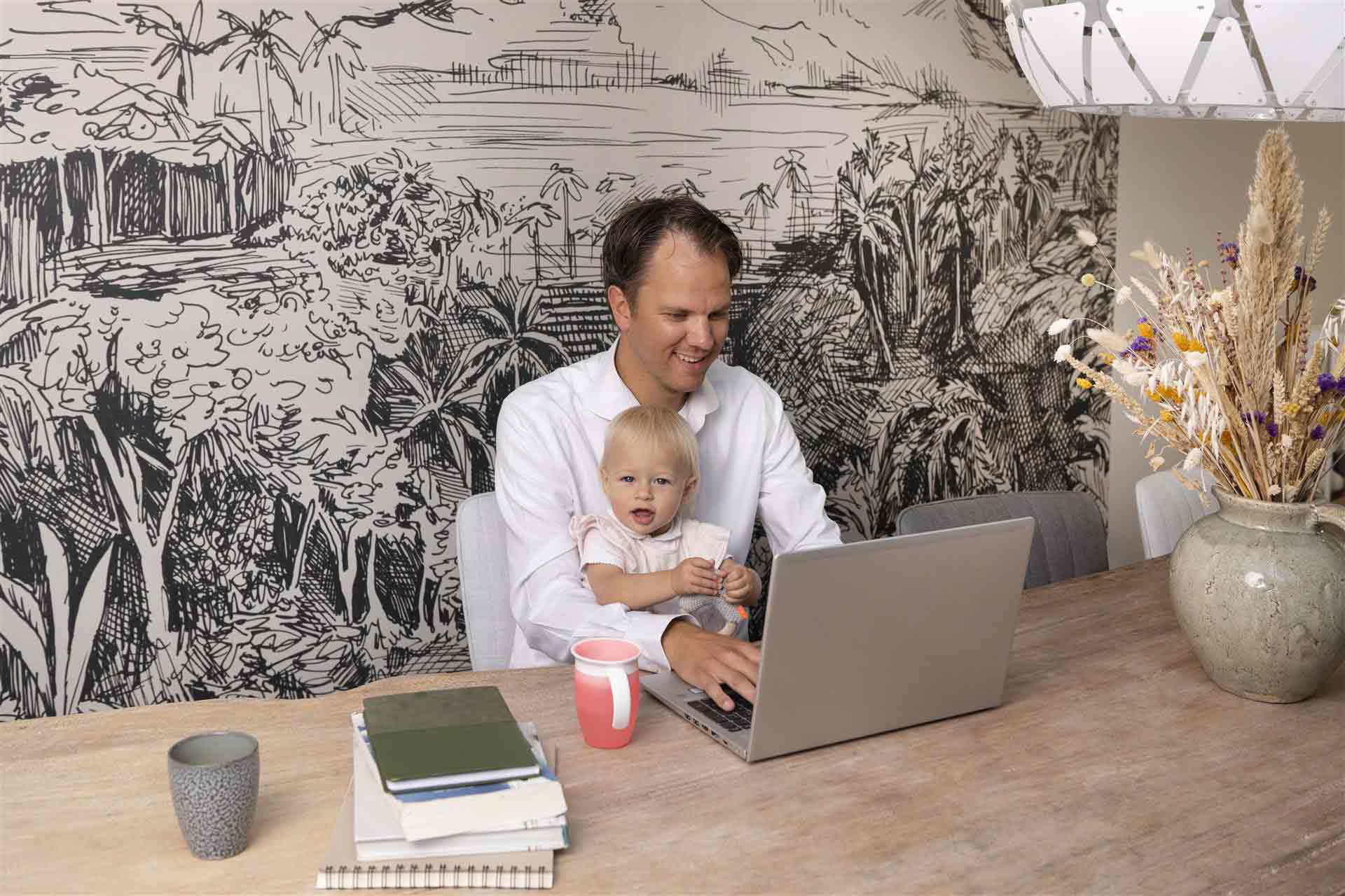 Vader zit met dochter van 2 jaar achter de laptop te werken aan zijn studie
